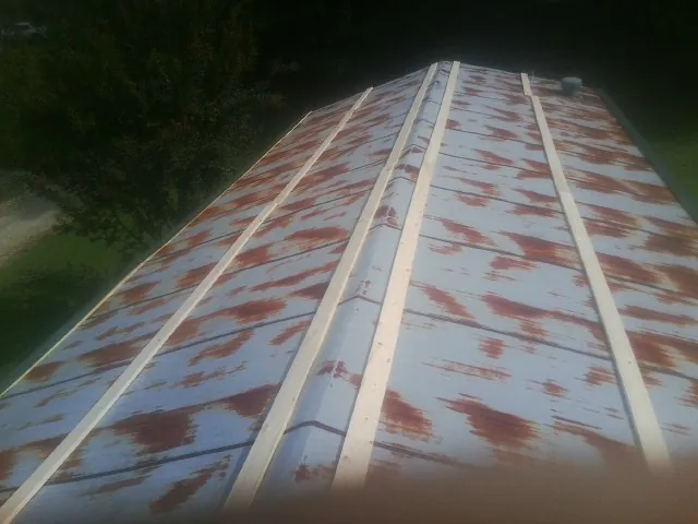 Rusted metal roof panels with new wood purlins before replacement — Storm Damage Roof Repair in Hector by Roofing Brothers